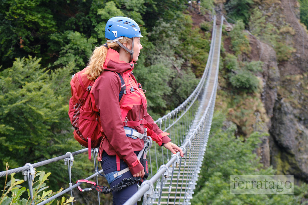 Woman with via ferrata gear on a steel wire bridge at Skalka, Kremnica, Slovakia