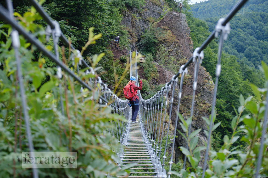 Woman with via ferrata gear on a steel wire bridge at Skalka, Kremnica, Slovakia